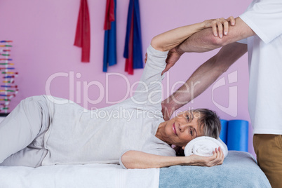 Physiotherapist massaging a senior womans shoulder