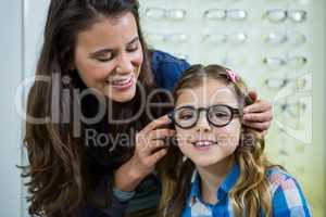 Mother prescribing spectacles to her daughter