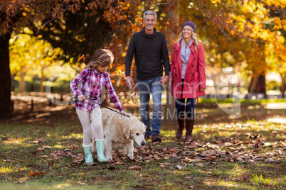 Girl with dog while parents walking at park