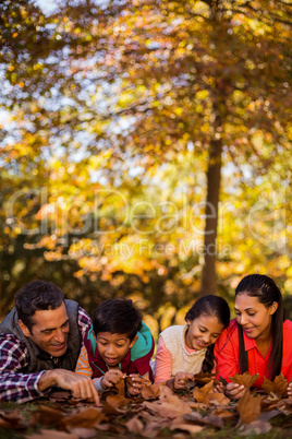 Playful family lying at park during autumn