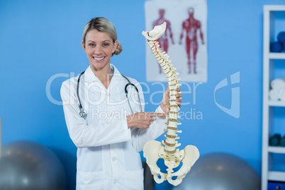 Portrait of physiotherapist holding spine model