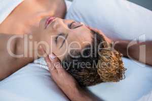 Woman receiving head massage from physiotherapist