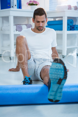 Man performing exercise using foam roll