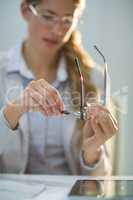 Female optometrist preparing glass frame