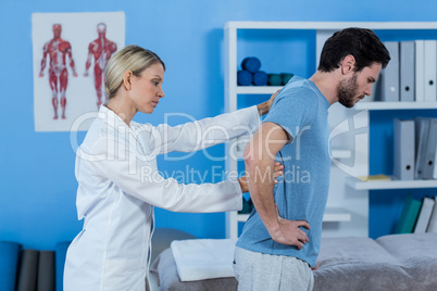 Physiotherapist examining mans back