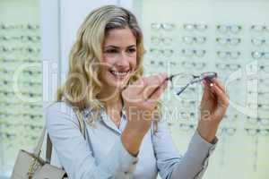 Smiling female customer trying spectacles