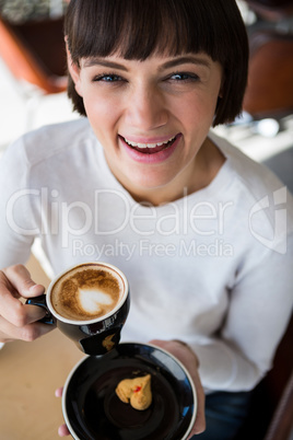 Woman having cup of coffee in cafeteria