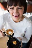 Woman having cup of coffee in cafeteria