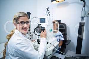 Female optometrist examining young patient on coreometry