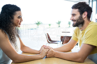 Couple holding hands in coffee shop
