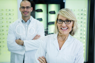 Smiling optometrists standing with arms crossed