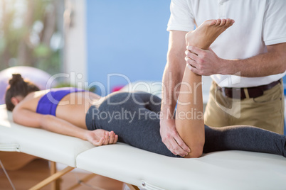 Male physiotherapist giving knee massage to female patient