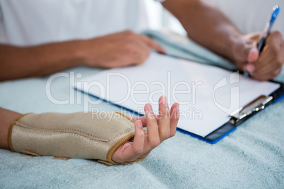 Physiotherapist examining hand of a female patient