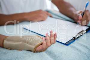 Physiotherapist examining hand of a female patient