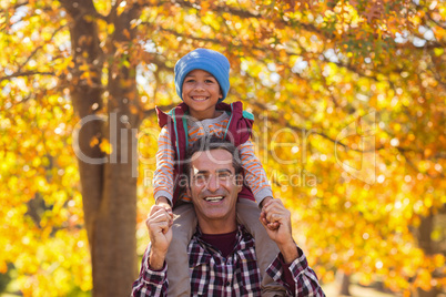 Happy father piggybacking son during autumn