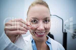 Female optometrist looking through magnifying glass