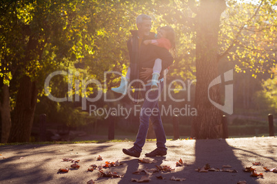 Father piggybacking daughter at park