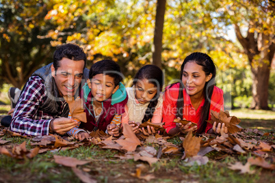 Family lying on field at park during autumn