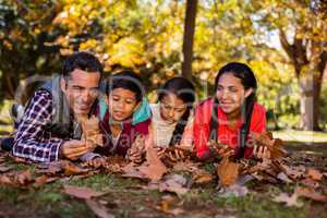 Family lying on field at park during autumn