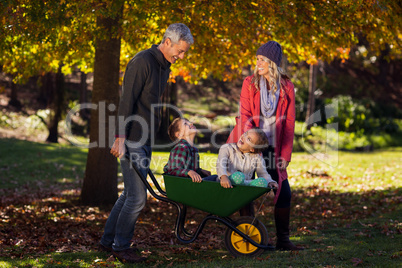 Cheerful family playing with the wheelbarrow