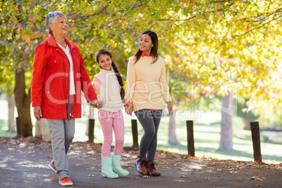 Daughter with mother and grandmother walking at park