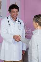 Physiotherapist shaking hands with female patient