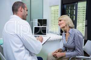 Male optometrist talking to female patient