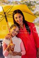 Mother and daughter with umbrella at park