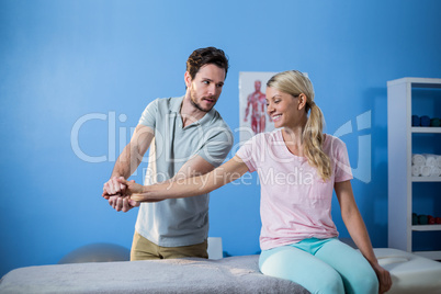 Physiotherapist massaging hand of a female patient