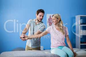 Physiotherapist massaging hand of a female patient