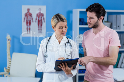 Physiotherapist explaining diagnosis to male patient