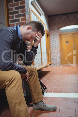Stressed mature student sitting in locker room Stressed mature student sitting in locker room