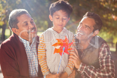 Boy holding pinwheel toy with family