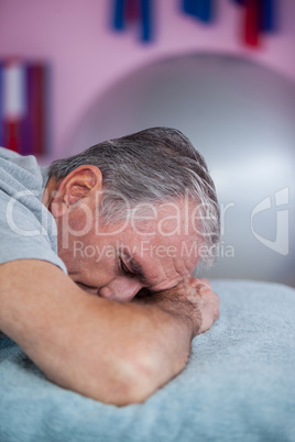 Senior man lying on a massage bed