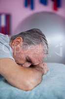 Senior man lying on a massage bed