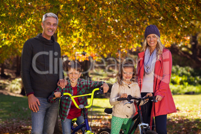 Children riding bicycles with parents at park