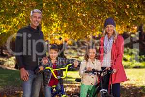 Children riding bicycles with parents at park