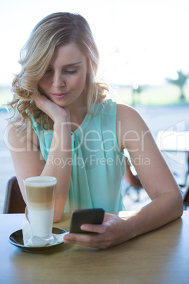 Woman using her mobile phone in the coffee shop