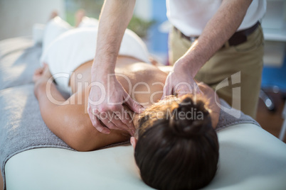 Physiotherapist giving physical therapy to the neck of a female