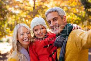 Portrait of smiling family against trees