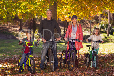 Happy family riding bicycles at park