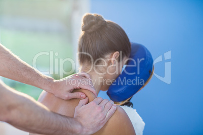 Physiotherapist giving shoulder massage to a female patient