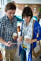 Couple with coffee cups using a digital tablet