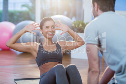 Physiotherapist assisting a female patient while exercising Physiotherapist assisting a female patient while exercising