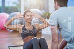 Physiotherapist assisting a female patient while exercising