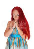 Woman praying with hands folded.
