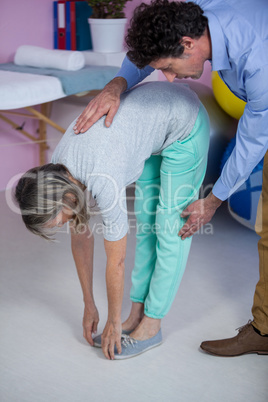 Physiotherapist examining womans back