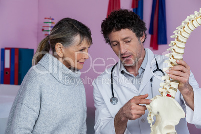 Physiotherapist explaining the spine model to patient