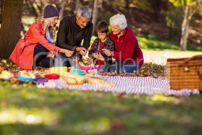 Family holding autumn leaves at park