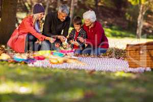Family holding autumn leaves at park